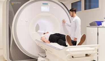 Patient wird von einem Arzt der Neuroradiologie in einem MRT untersucht.